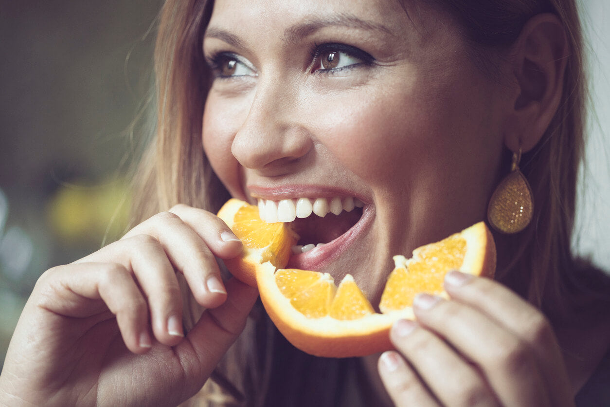 a woman eating an orange