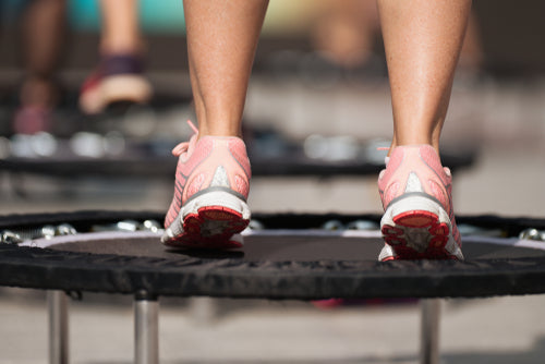 women jumping on small trampolines