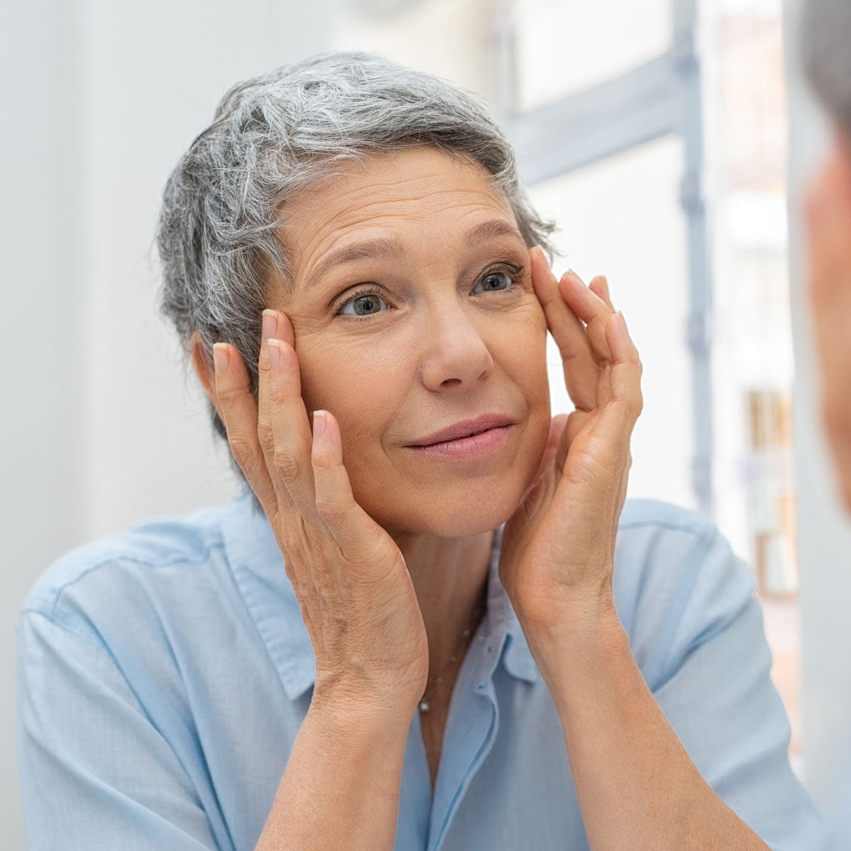 Elderly woman looking at her reflection in the mirror