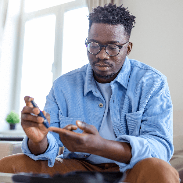 Man with diabetes pricking his finger for glucose test