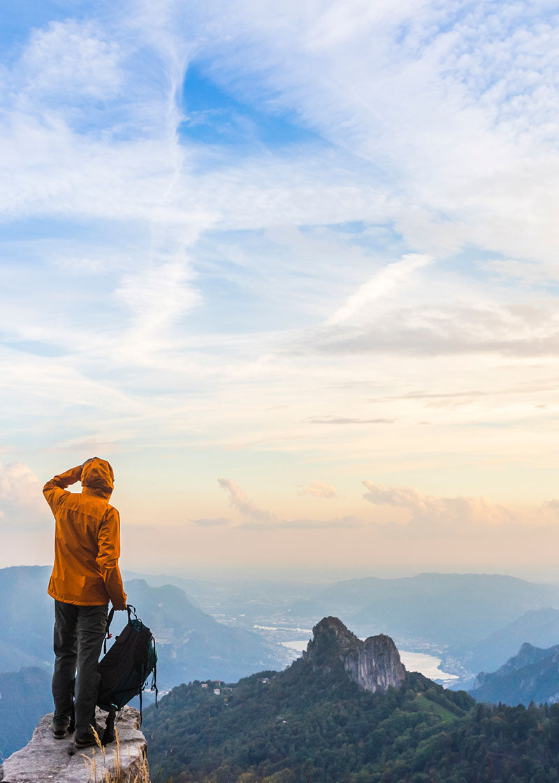 Healthy adventurous hiker overlooking mountainous landscape at sunrise