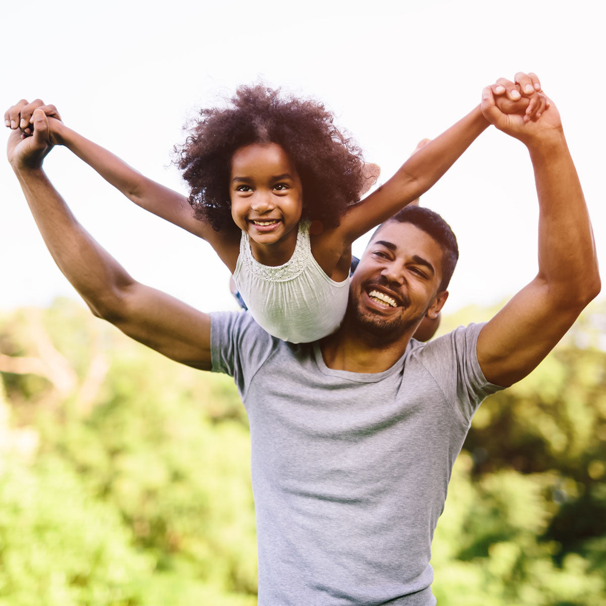 Father holding his daughter over his shoulders