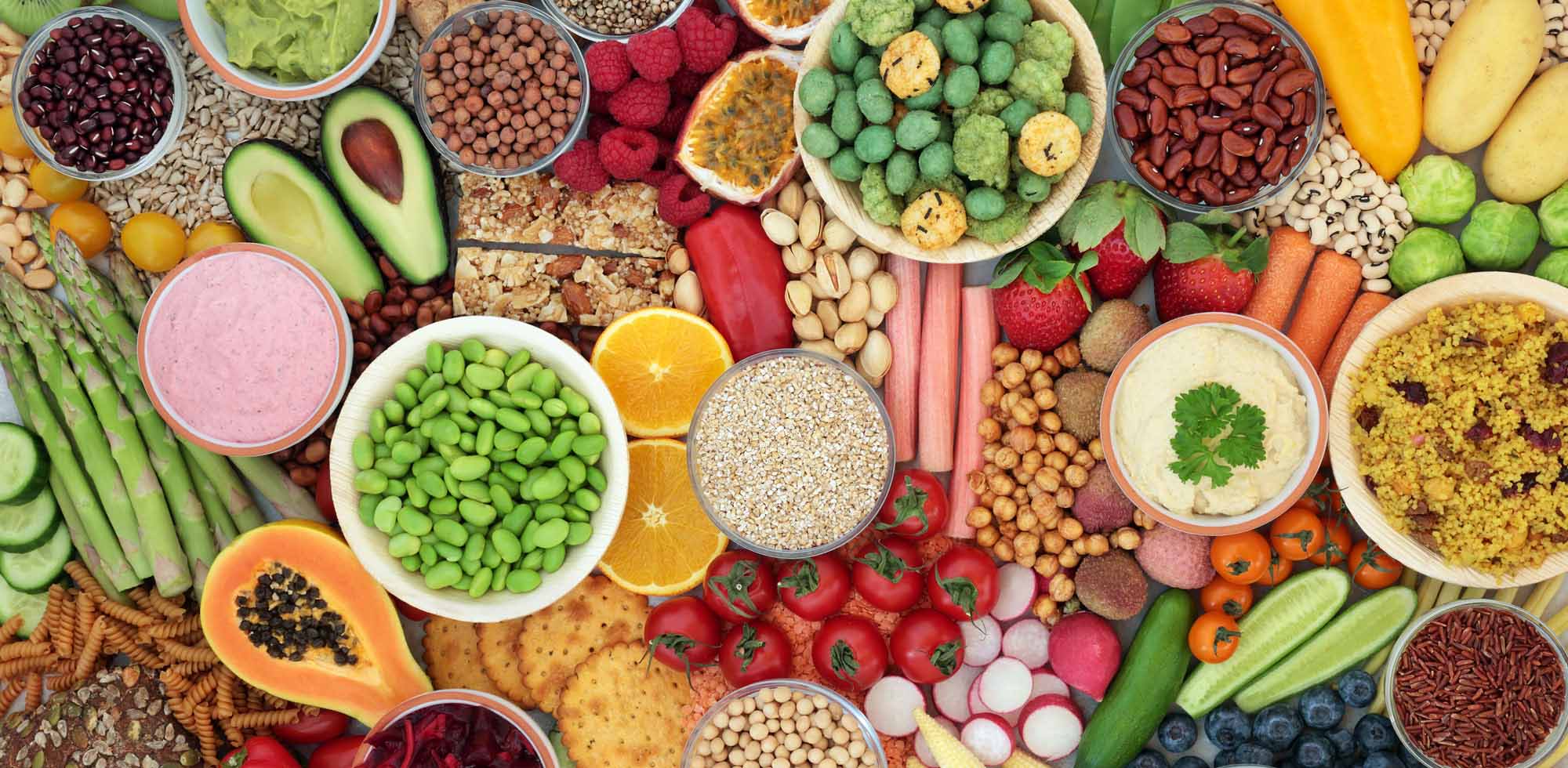 Mixed raw vegetables, fruits, nuts, seeds, and legumes for a healthy and balanced vegan diet