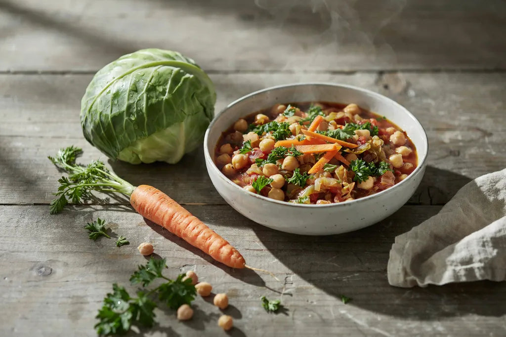 Tuscan Soup with Cabbage - a white bowl of reddish chickpea and cabbage stew