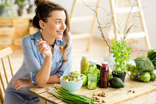 Young and happy woman eating healthy salad