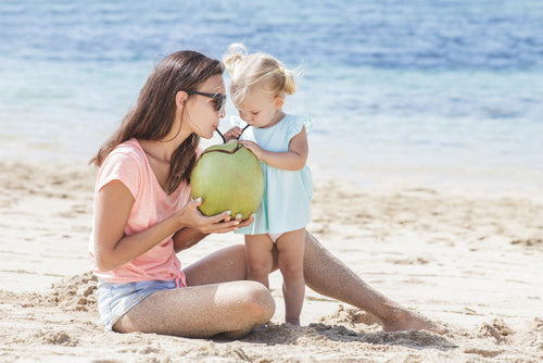 girl with mother drinking coconut water