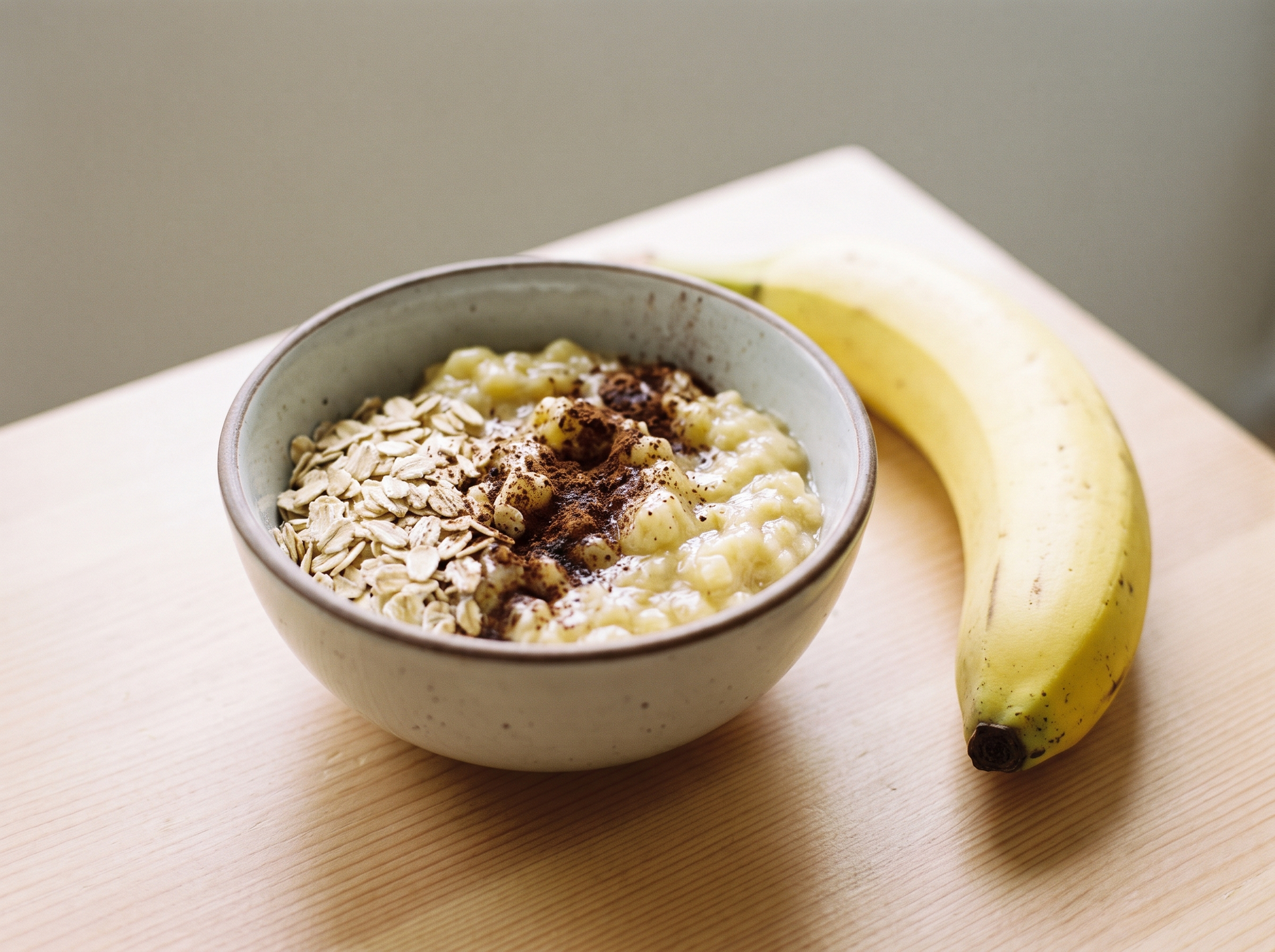 Bowl of banana carob oatmeal snack made with banana, raw oats and carob powder