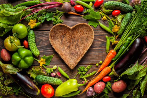 plate heart surrounded by vegetables