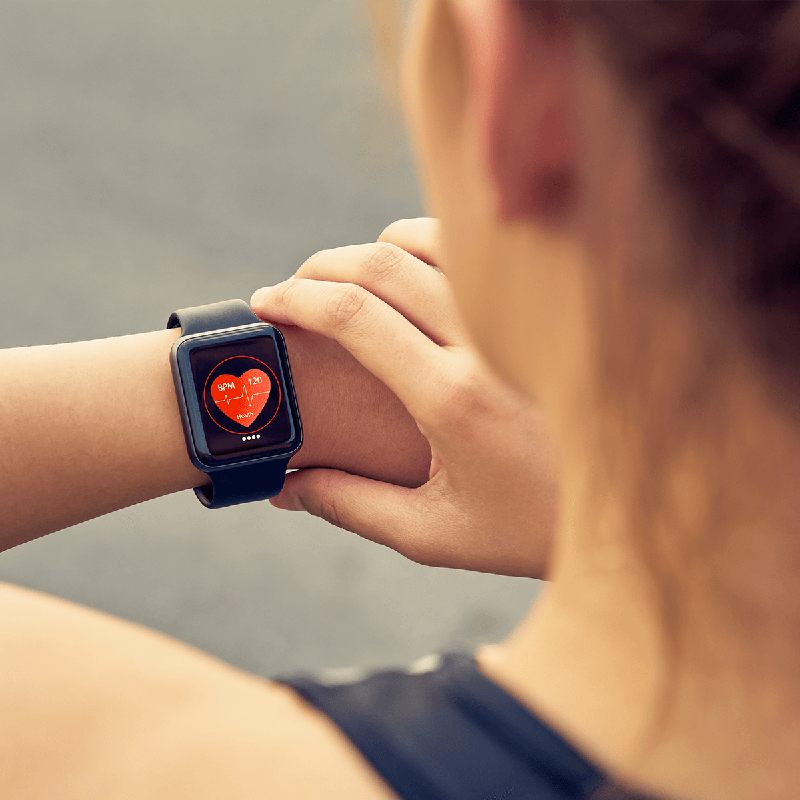 Woman checking smart watch to monitor heart health