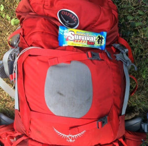 Red backpack with a Survival Bar for hiking