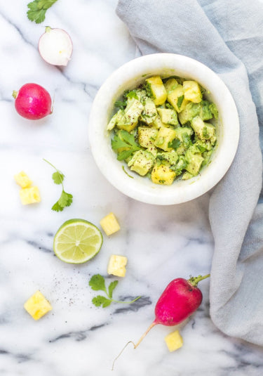 Healthy vegan snack made with radishes, avocado, pineapple, and cilantro